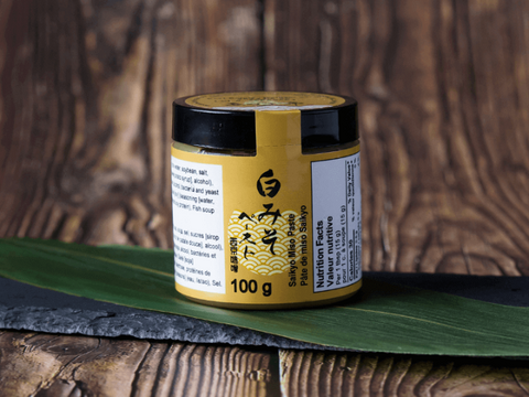 Shinshu Miso Paste 100g jar on a wooden table with a green leaf decoration
