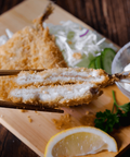 Aji Fry 60g - Breaded horse mackerel paired with lemon wedge, coleslaw, and dipping sauce on a wooden board